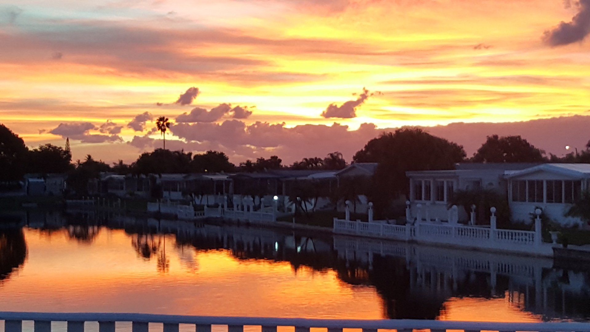 Sunset over the lakes and homes at The Estates of Fort Lauderdale